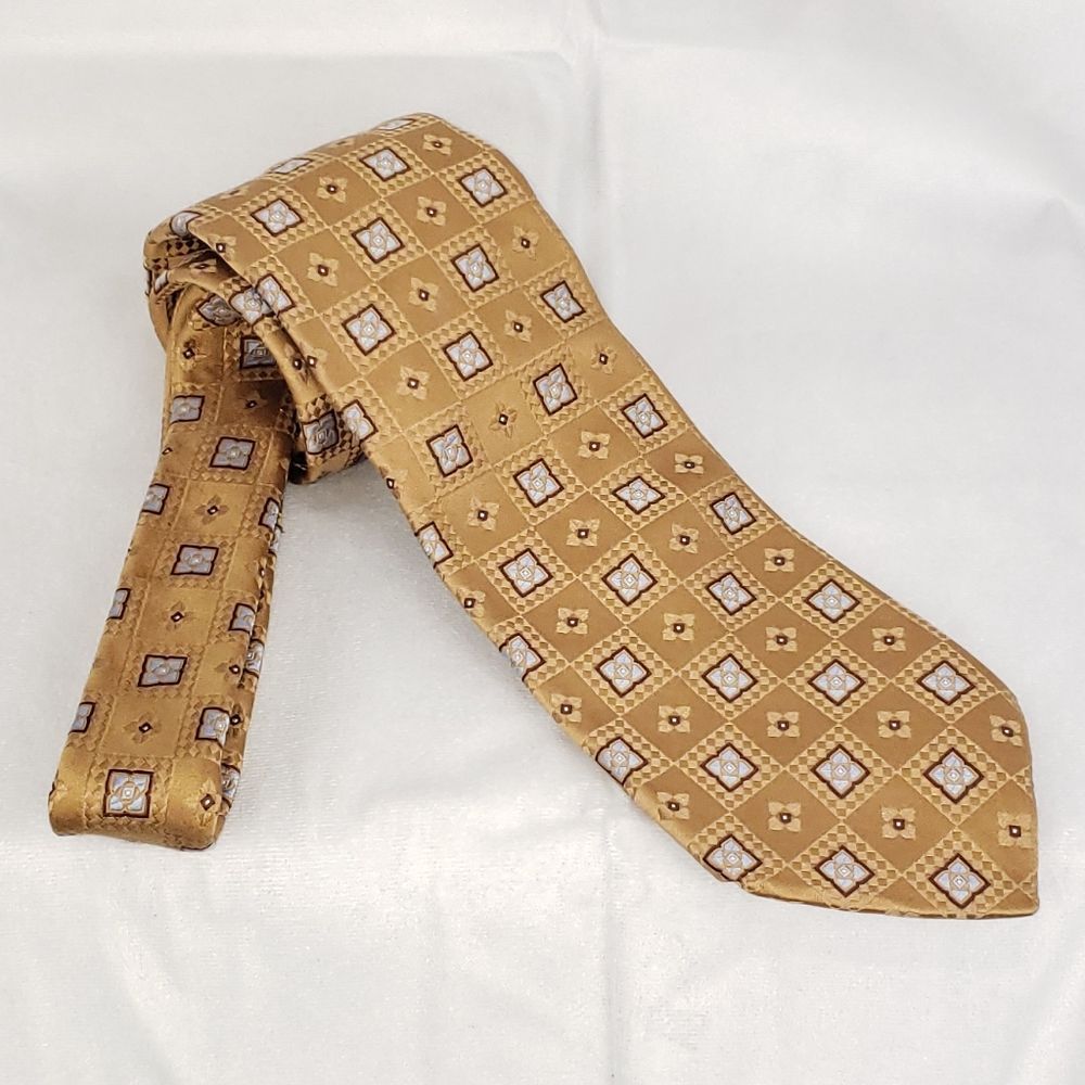 Ike Behar silk tie. L 60" W 3 1/2". Light Brown with blue geometric pattern.